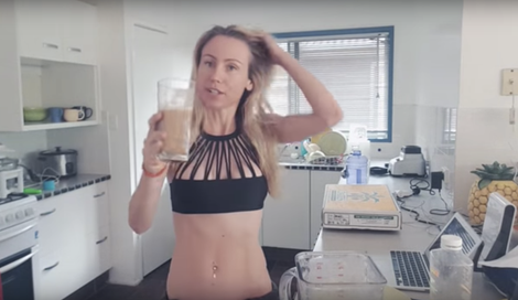 Freelee drinks a fruit smoothie, showing off her “flat belly gains.” (Image via YouTube)